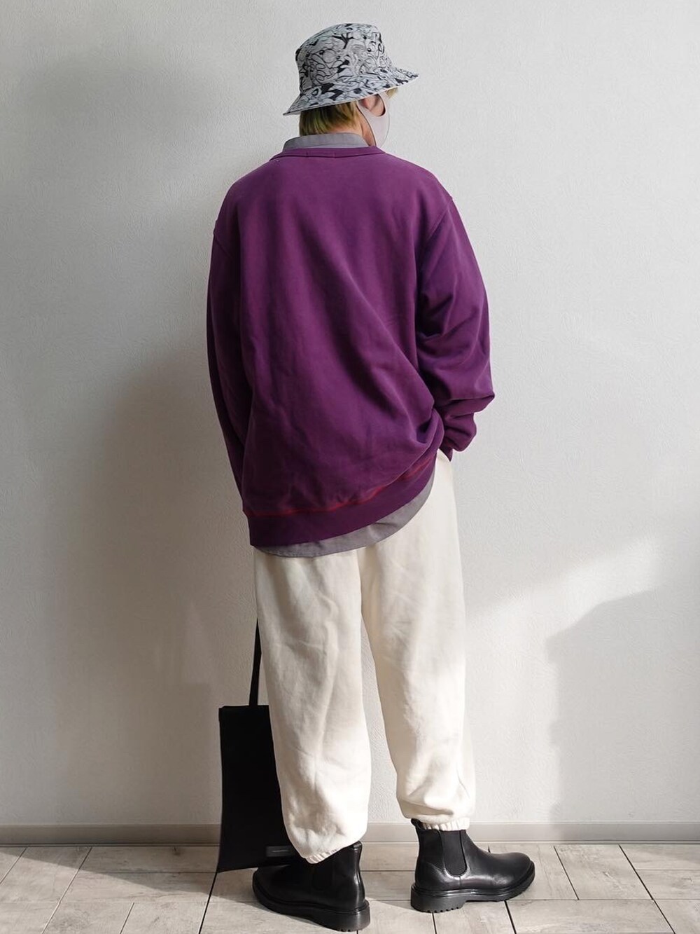 ホワイト系のスウェットパンツ、ブラック系のブーツ、ブラック系のトートバッグを着用したメンズの冬コーディネートの3枚目の写真