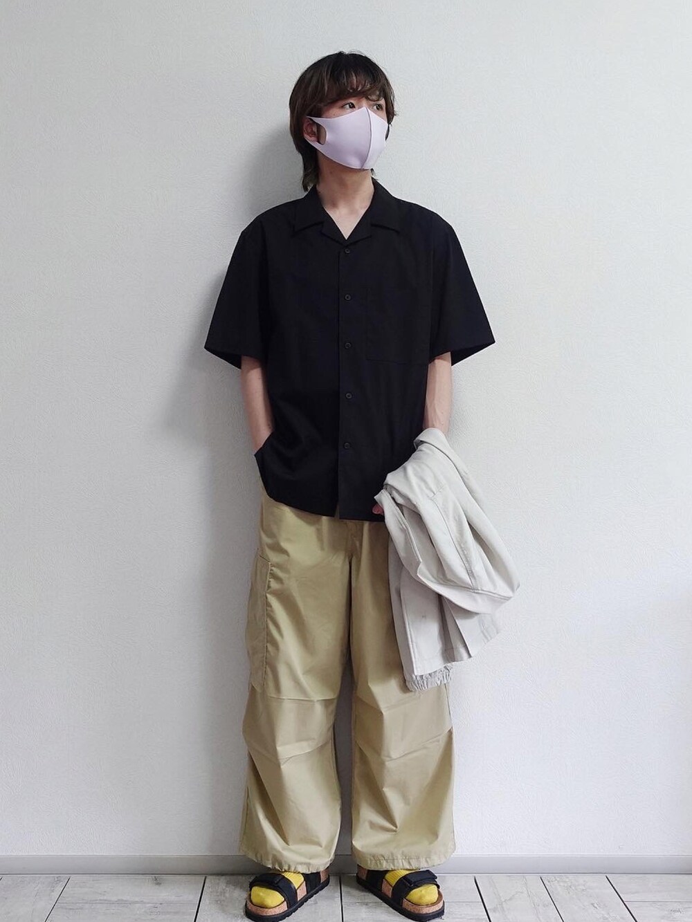 ホワイト系のブルゾン、ベージュ系のカーゴパンツ、ブラック系のサンダルを着用したメンズの春コーディネートの2枚目の写真