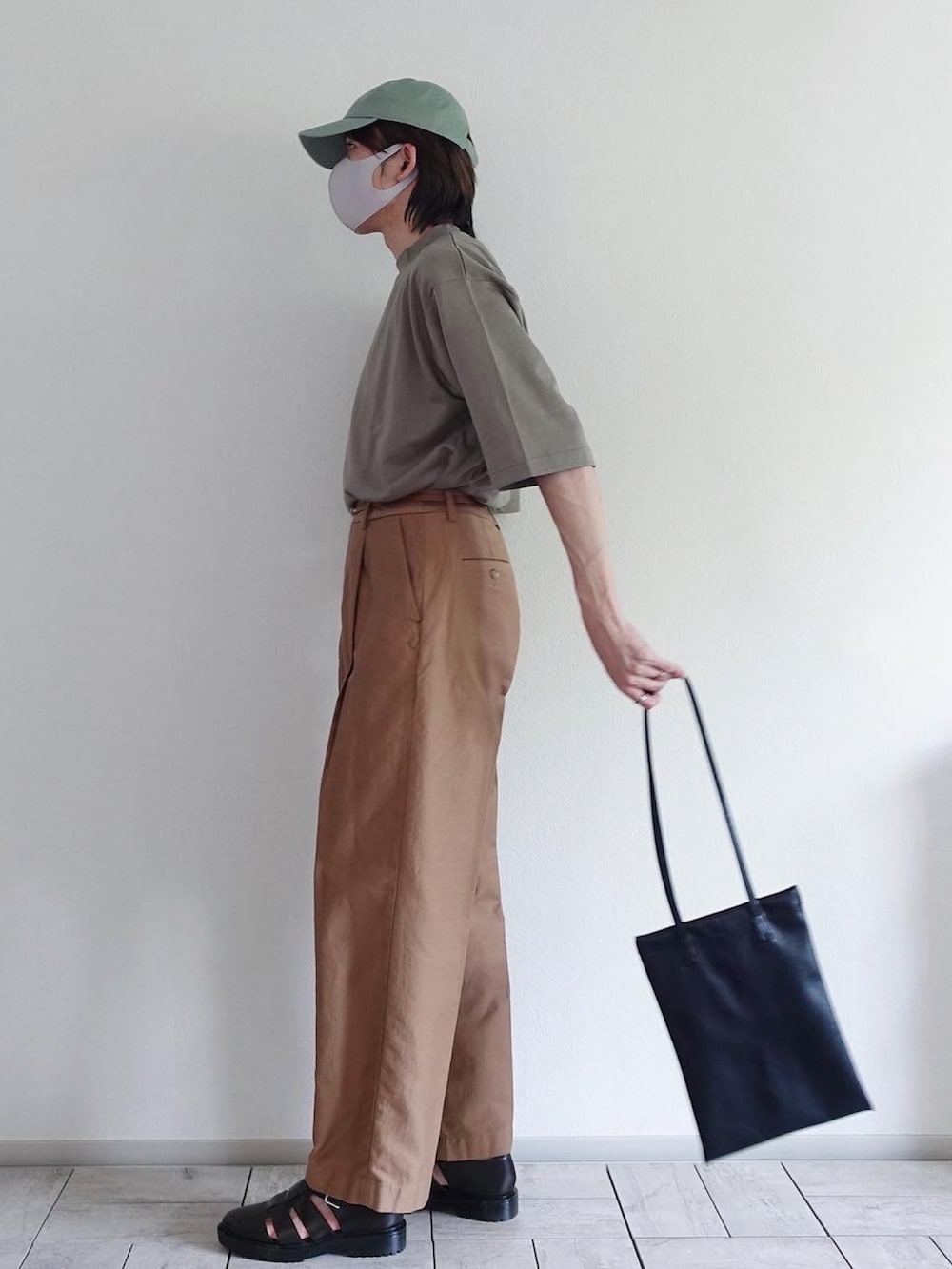 ホワイト系のスウェットパンツ、ベージュ系のスラックス、ブラック系のトートバッグを着用したメンズの夏コーディネートの2枚目の写真