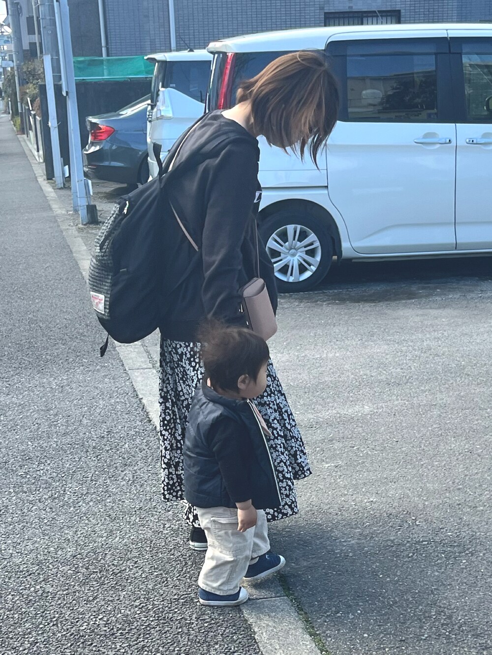 ブラック系のスウェット、ブラック系のスニーカー、ブルー系のスニーカーを着用したレディースの春コーディネートの2枚目の写真