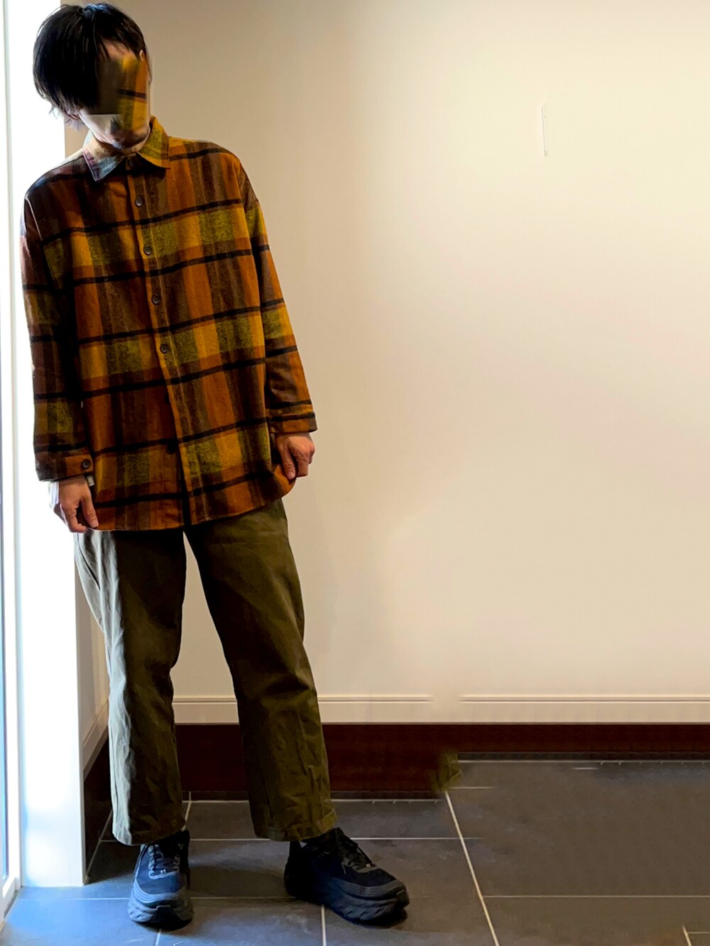 ブラック系のその他アウター、ブラック系のTシャツ/カットソー、オレンジ系のシャツ/ブラウスを着用したメンズの冬コーディネートの2枚目の写真