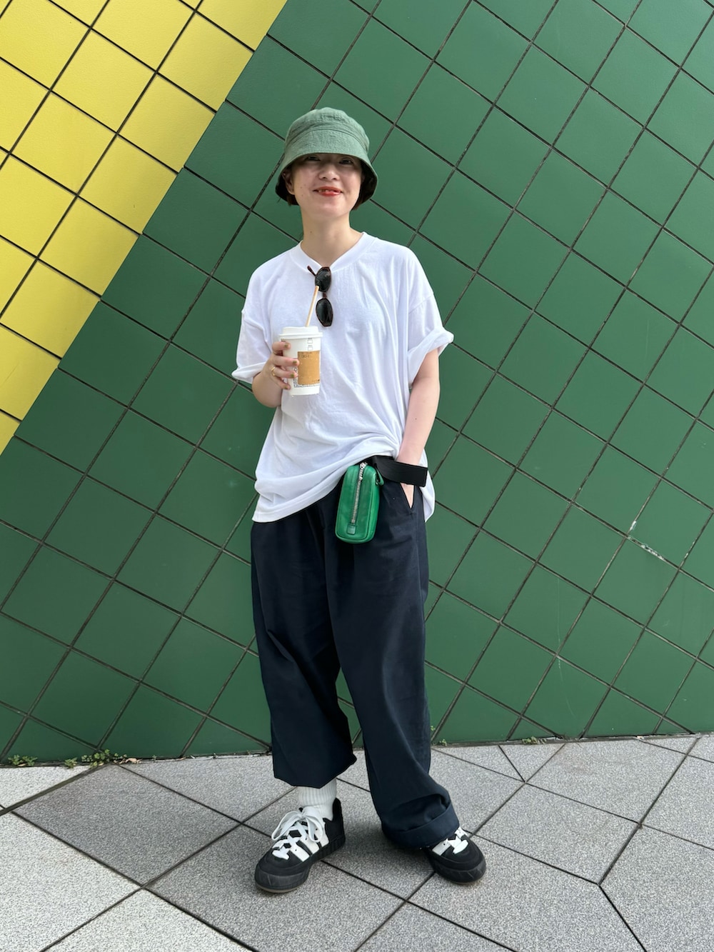 ブルー系のスラックス、ブラック系のスニーカーを着用したレディースの夏コーディネートの2枚目の写真