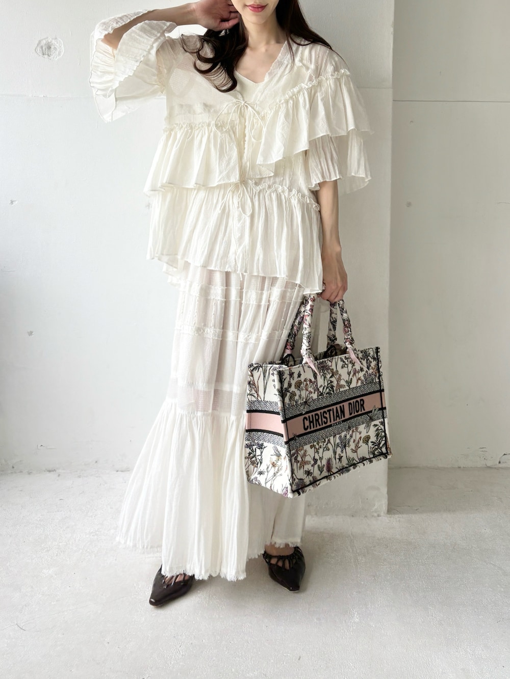 ホワイト系のシャツ/ブラウス、ホワイト系のスカート、ブラウン系のサンダルを着用したレディースの夏コーディネートの2枚目の写真