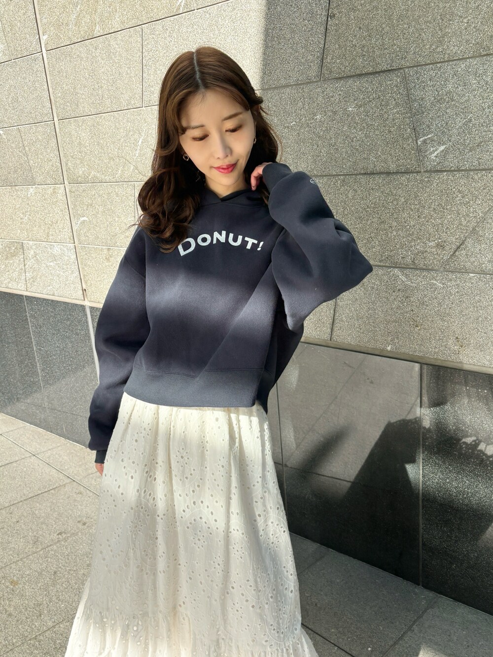 ブルー系のパーカー、ホワイト系のスカート、ブラウン系のブーツを着用したレディースの冬コーディネートの3枚目の写真