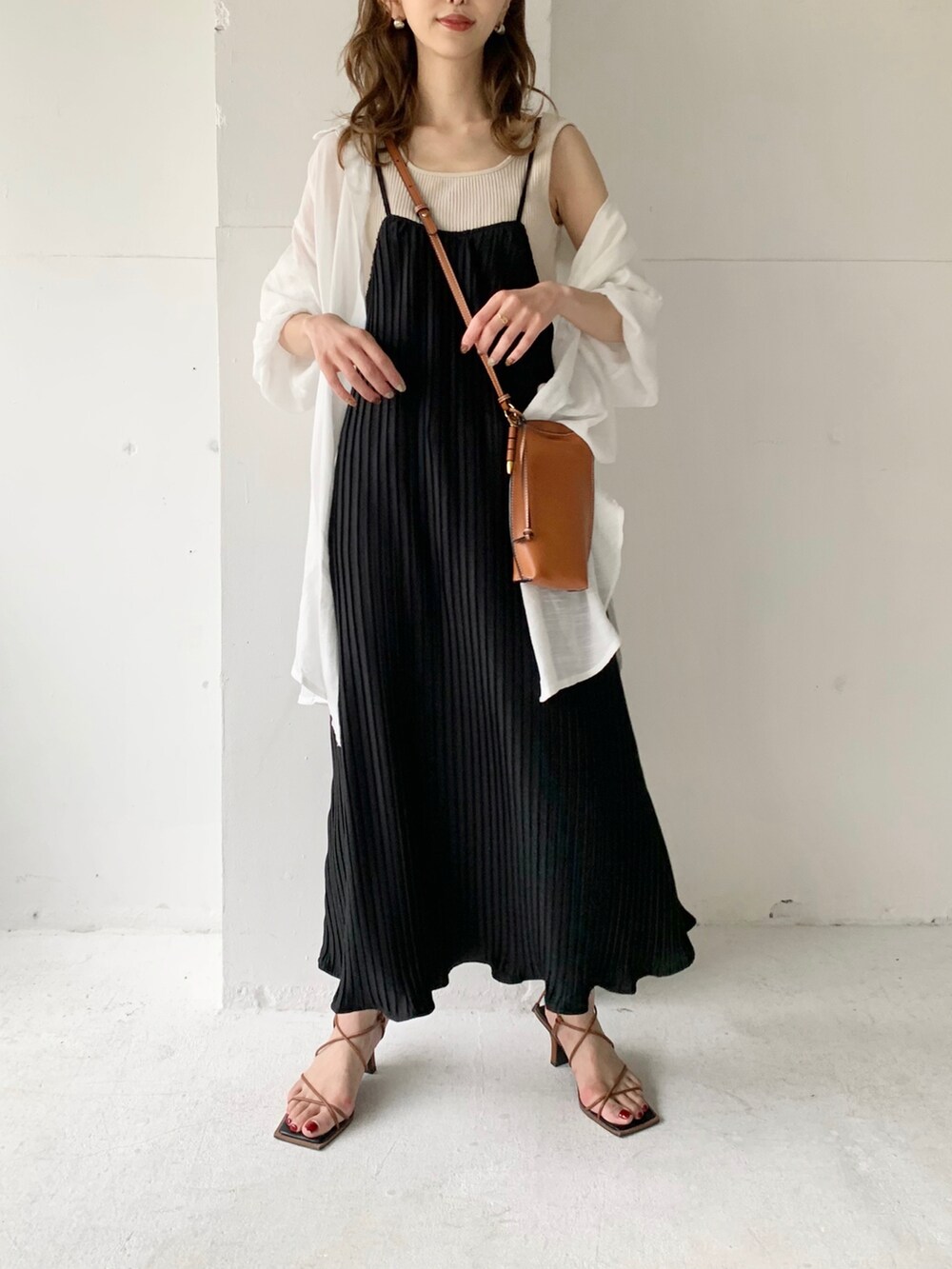 ブラック系のワンピース、ホワイト系のシャツ/ブラウス、ゴールド系のイヤリングを着用したレディースの夏コーディネートの4枚目の写真