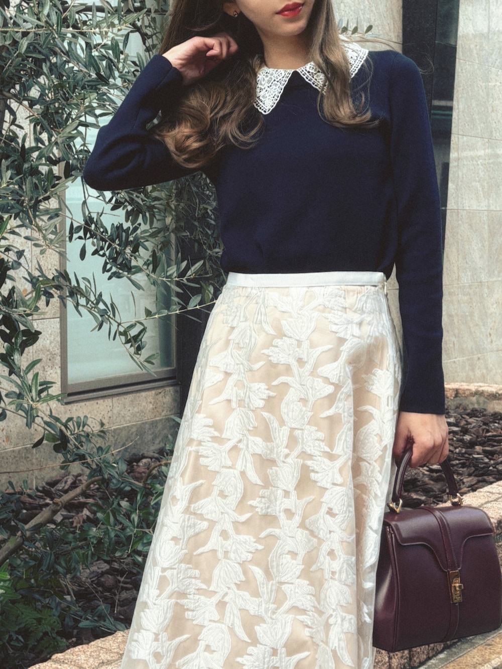 ブルー系のニット/セーター、ホワイト系のスカートを着用したレディースの秋コーディネートの2枚目の写真