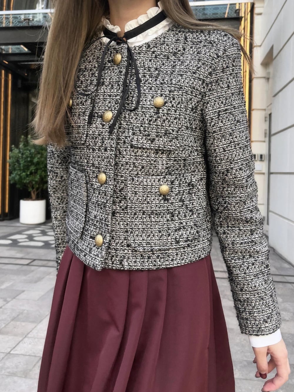 グレー系のノーカラージャケット、レッド系のスカート、ホワイト系のシャツ/ブラウスを着用したレディースの秋コーディネートの2枚目の写真