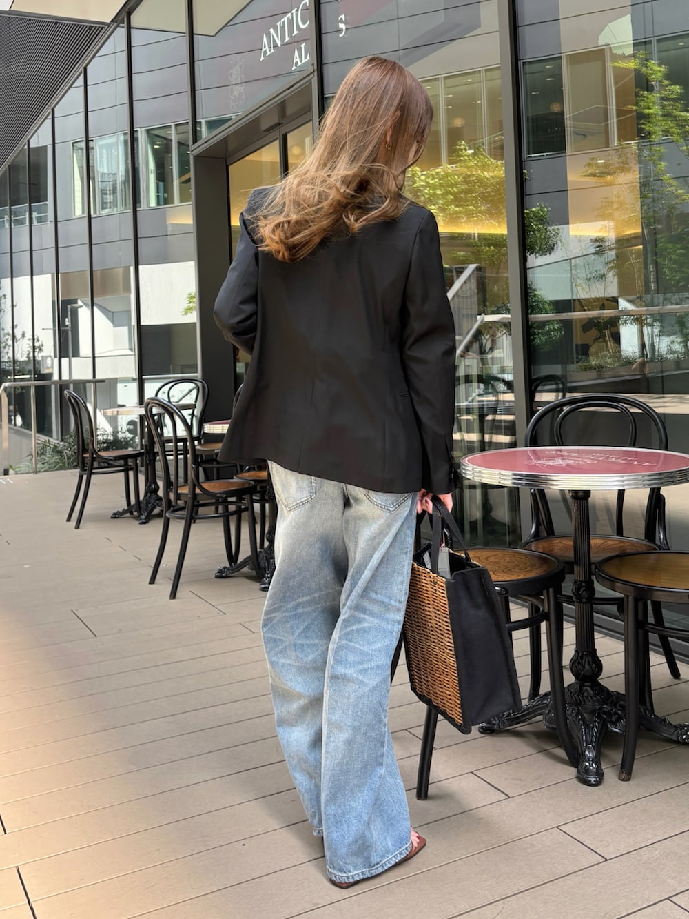 ブラック系のテーラードジャケット、ホワイト系のシャツ/ブラウス、ブラウン系のサンダルを着用したレディースの春コーディネートの2枚目の写真