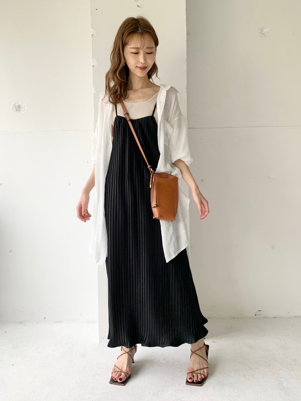 ブラック系のワンピース、ホワイト系のシャツ/ブラウス、ゴールド系のイヤリングを着用したレディースの夏コーディネートの2枚目の写真