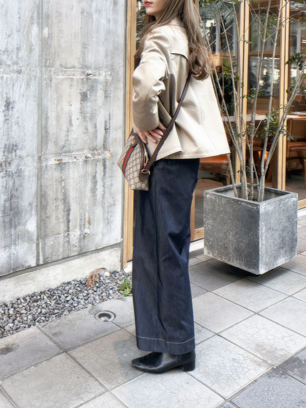 ベージュ系のトレンチコート、ホワイト系のシャツ/ブラウス、ブルー系のその他パンツを着用したレディースの春コーディネートの2枚目の写真