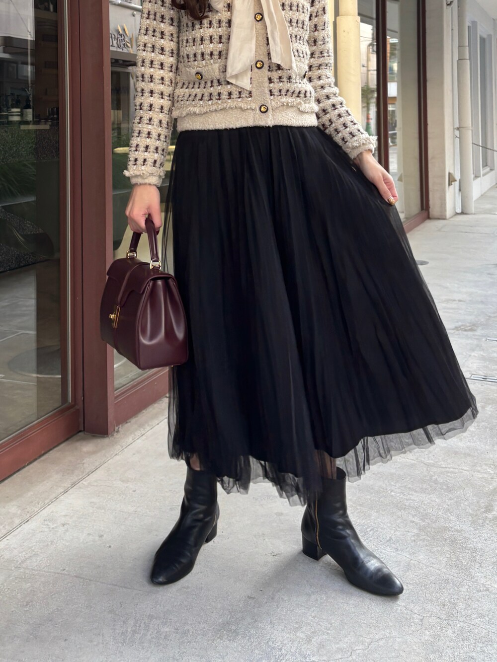 ベージュ系のカーディガン/ボレロ、ホワイト系のシャツ/ブラウス、ブラック系のスカートを着用したレディースの冬コーディネートの4枚目の写真