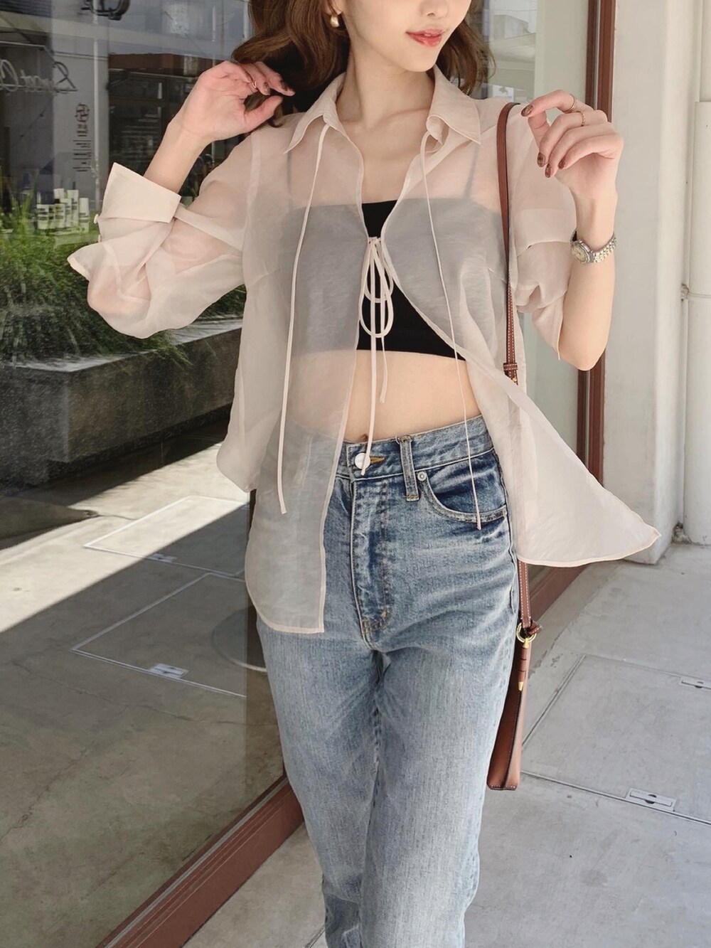 ホワイト系のシャツ/ブラウス、ブラック系のチューブトップ、ブルー系のデニムパンツを着用したレディースの春コーディネートの4枚目の写真