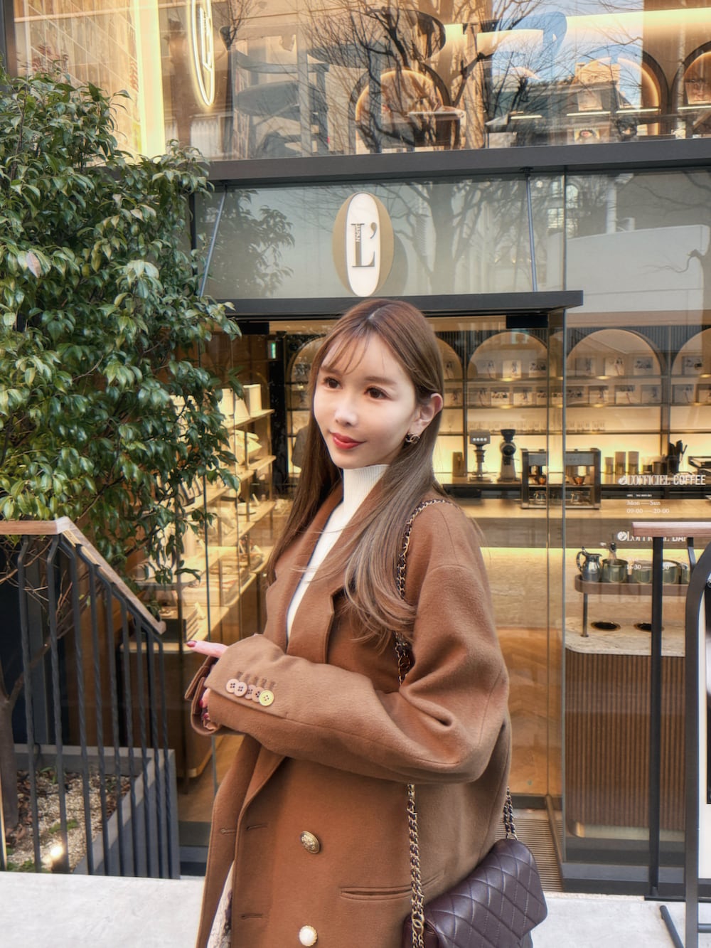 ベージュ系のジャケット/アウター、ホワイト系のスカート、ホワイト系のニット/セーターを着用したレディースの冬コーディネートの2枚目の写真