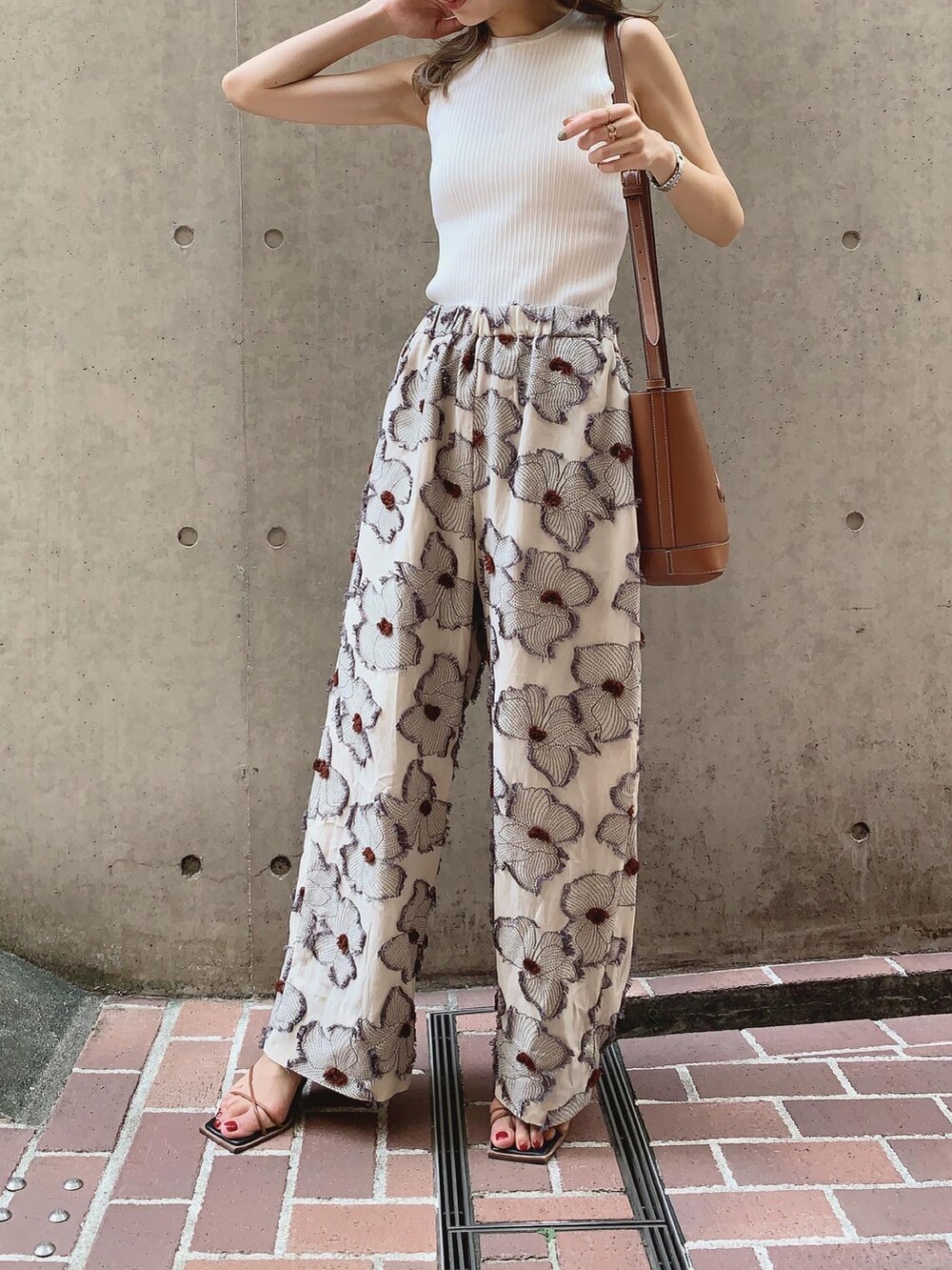 ホワイト系のタンクトップ、ブラウン系のサンダル、ベージュ系のハットを着用したレディースの夏コーディネートの2枚目の写真