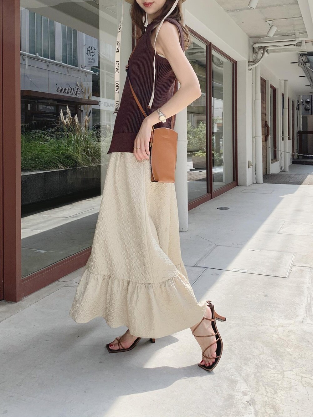 ブラウン系のベスト、ベージュ系のスカート、ブラウン系のサンダルを着用したレディースの秋コーディネートの3枚目の写真