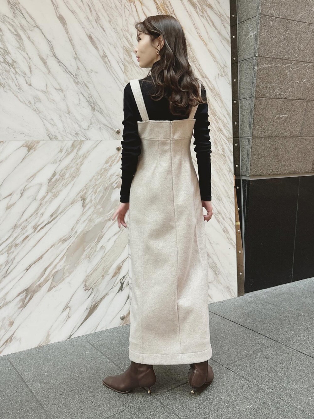 ベージュ系のジャンパースカート、ブラック系のTシャツ/カットソーを着用したレディースの冬コーディネートの3枚目の写真