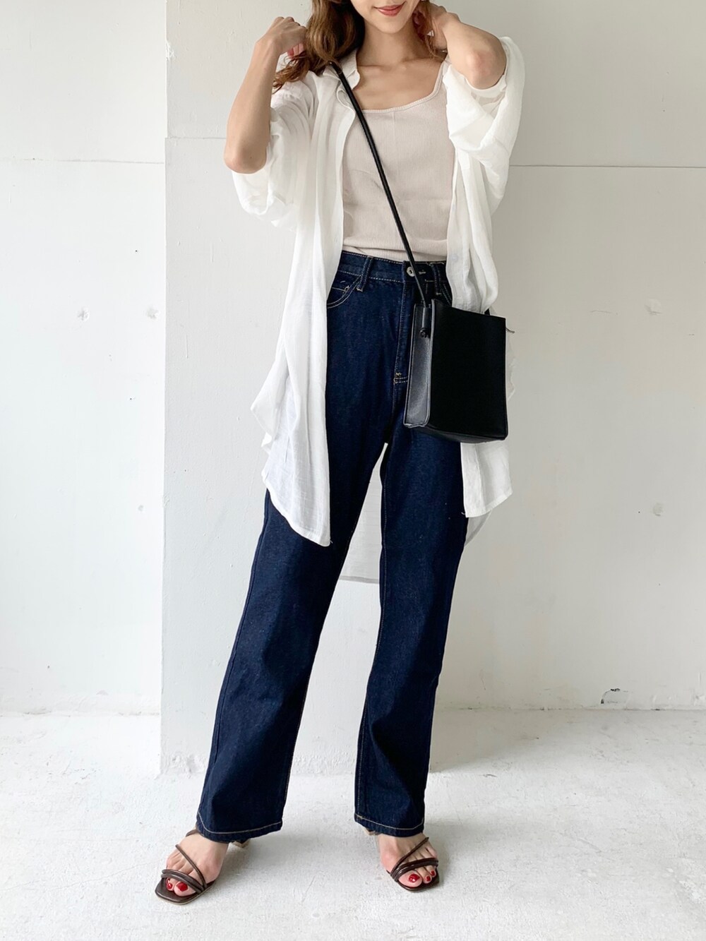 ブルー系のデニムパンツ、ホワイト系のシャツ/ブラウス、ベージュ系のタンクトップを着用したレディースの夏コーディネートの3枚目の写真