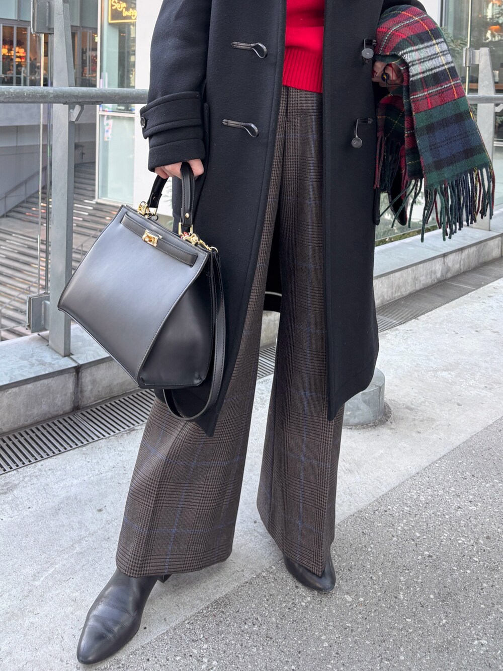 ブラック系のダッフルコート、レッド系のニット/セーター、ブラウン系のその他パンツを着用したレディースの冬コーディネートの3枚目の写真