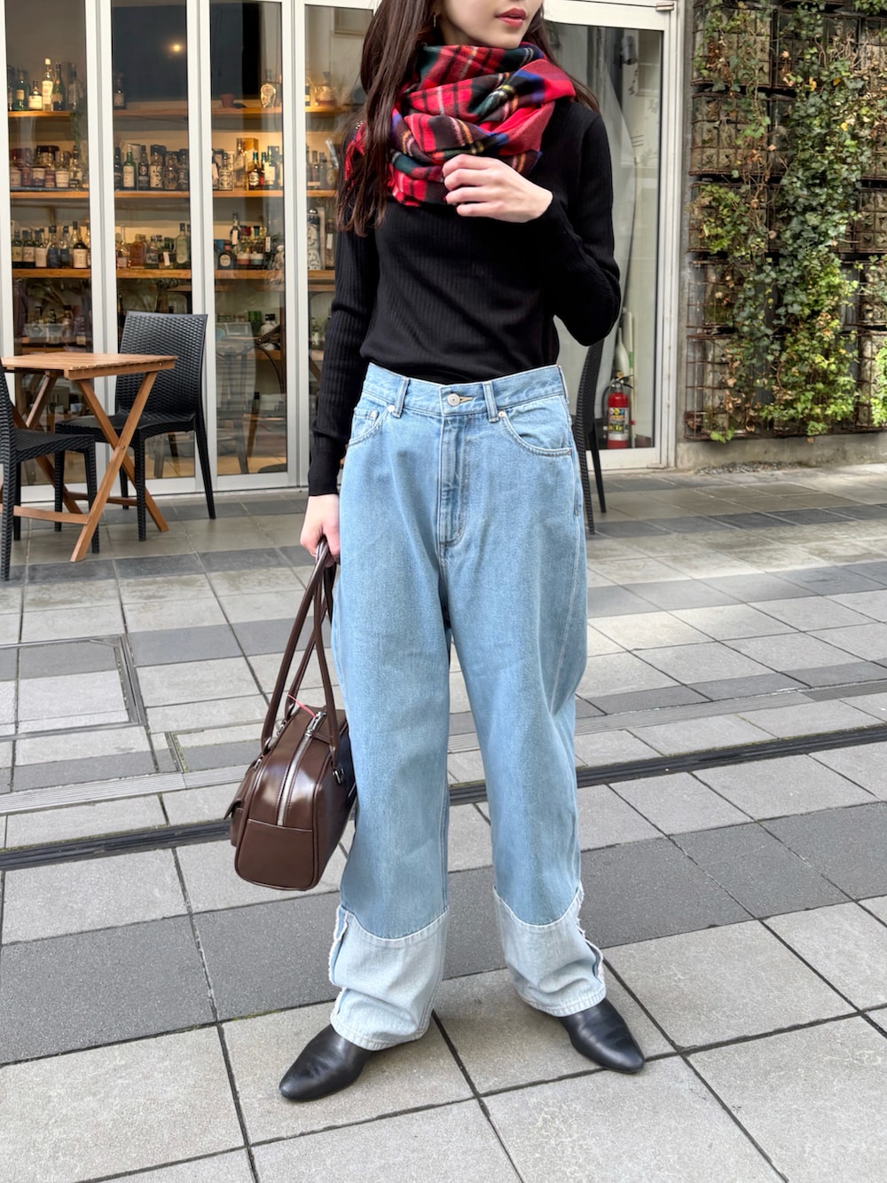 ブルー系のデニムパンツ、ブラック系のブーツ、ブラック系のニット/セーターを着用したレディースの冬コーディネートの2枚目の写真