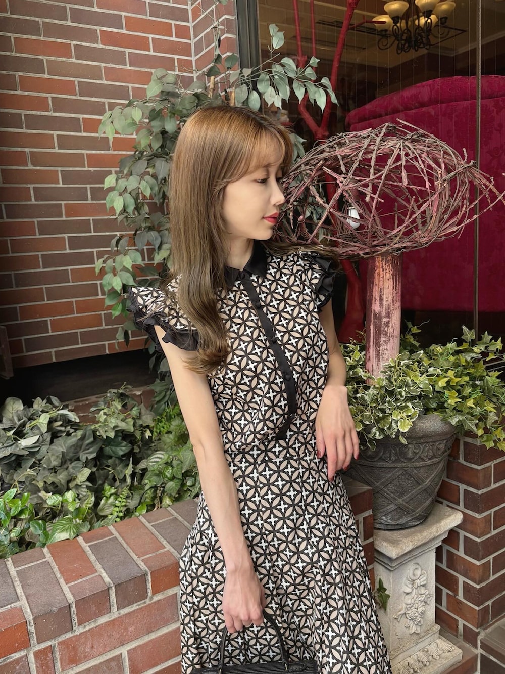 ベージュ系のシャツ/ブラウス、ベージュ系のスカート、ブラック系のサンダルを着用したレディースの夏コーディネートの2枚目の写真