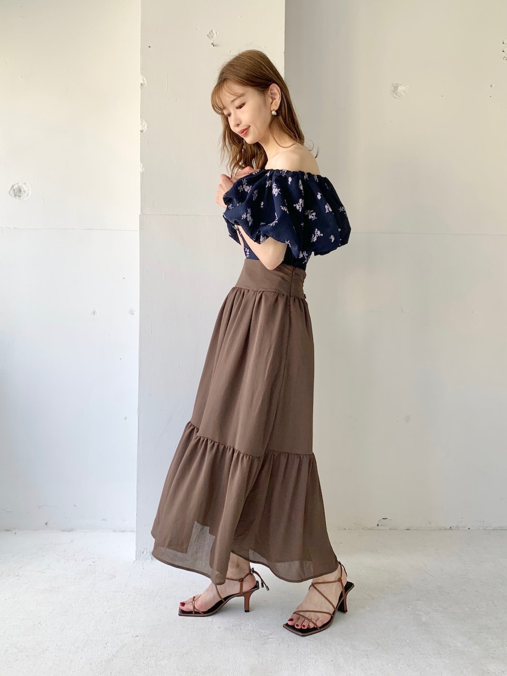 ブラウン系のスカート、ブルー系のシャツ/ブラウス、ブラウン系のサンダルを着用したレディースの春コーディネートの2枚目の写真