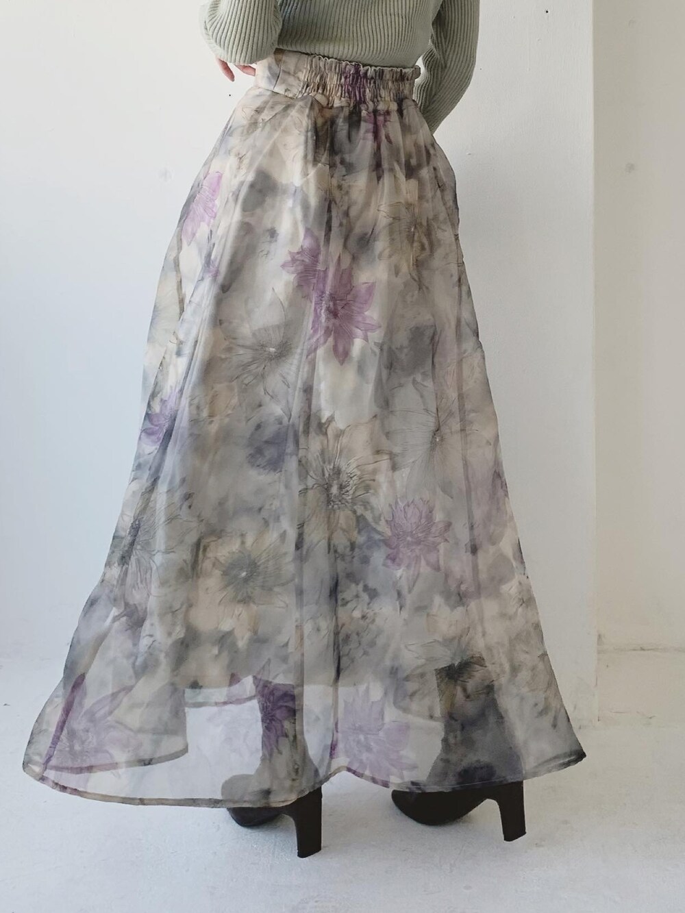 グリーン系のニット/セーター、グレー系のスカート、ブラウン系のブーツを着用したレディースの冬コーディネートの3枚目の写真