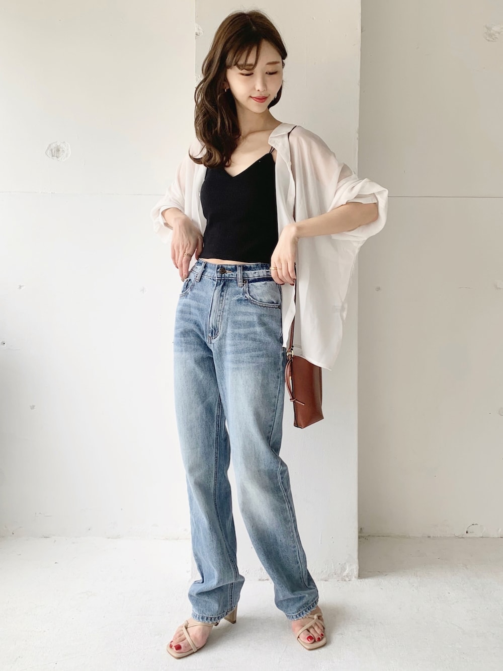 ホワイト系のシャツ/ブラウス、ブラック系のキャミソール、ブルー系のデニムパンツを着用したレディースの夏コーディネートの2枚目の写真