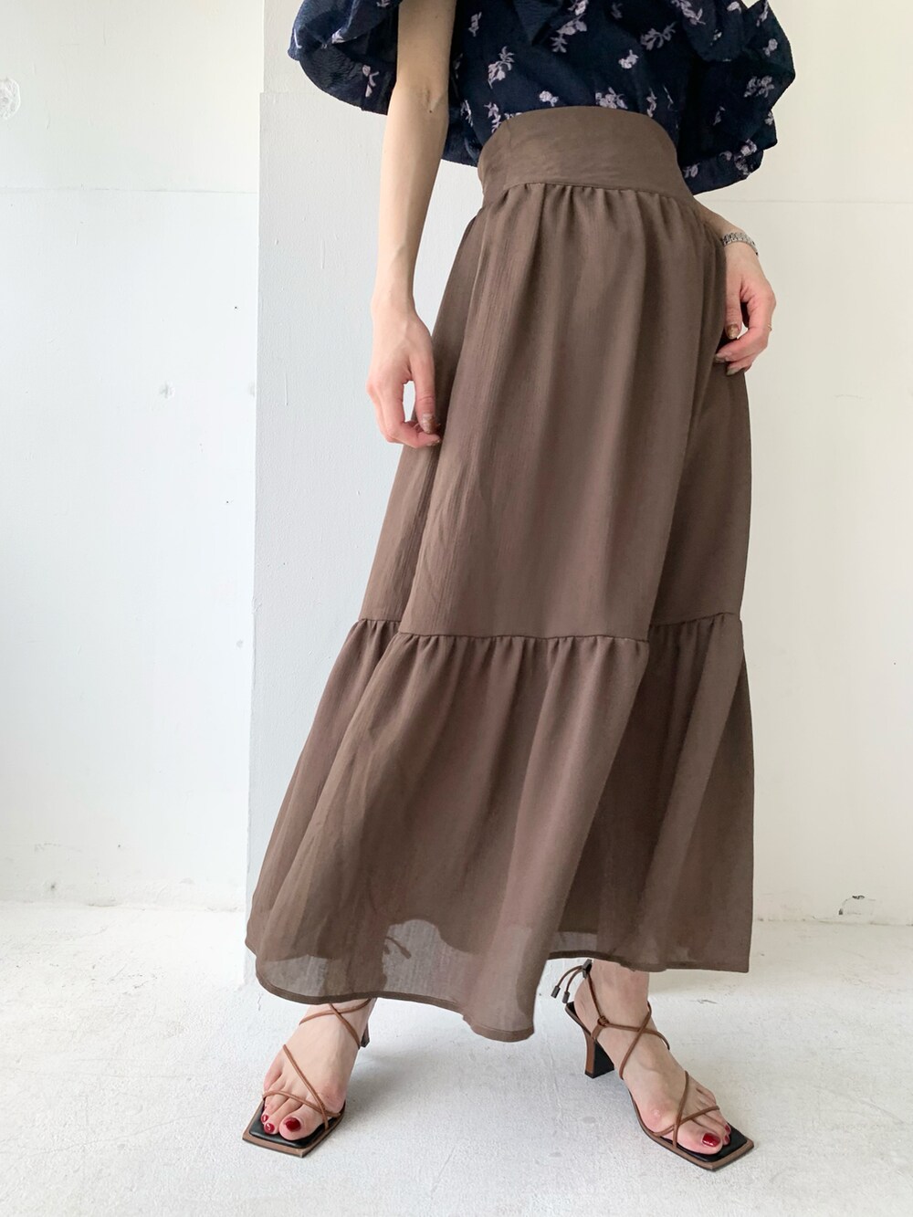 ブラウン系のスカート、ブルー系のシャツ/ブラウス、ブラウン系のサンダルを着用したレディースの春コーディネートの3枚目の写真