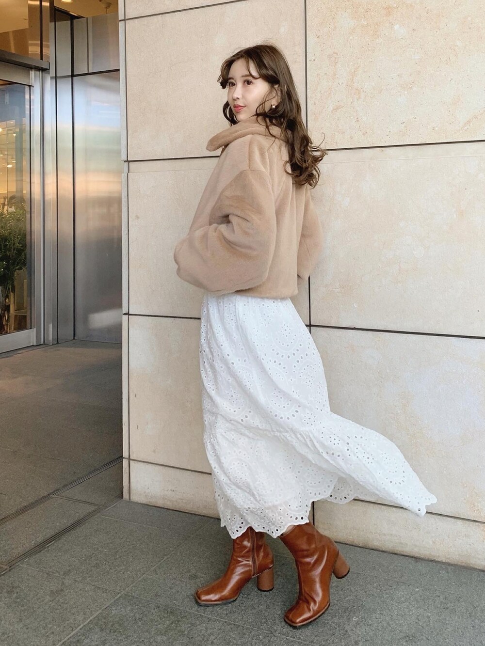 ホワイト系のスカート、ベージュ系のブルゾン、ブラウン系のブーツを着用したレディースの秋コーディネートの3枚目の写真