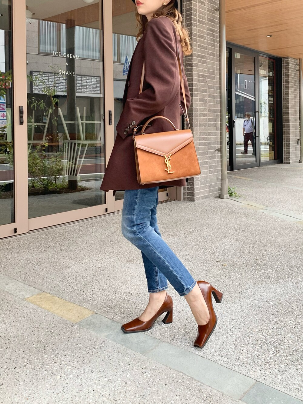 ブラウン系のテーラードジャケット、ホワイト系のTシャツ/カットソー、ブルー系のデニムパンツを着用したレディースの秋コーディネートの4枚目の写真