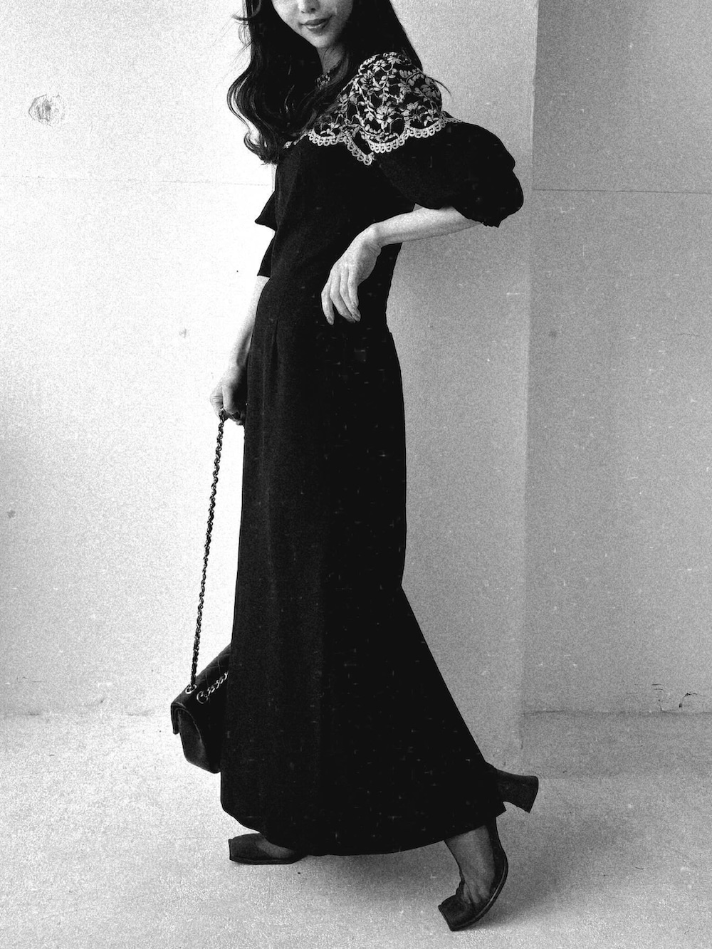 ブラック系のワンピース、ブラウン系のブーツを着用したレディースの春コーディネートの3枚目の写真