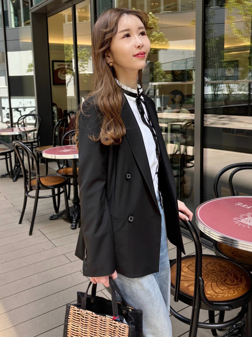 ブラック系のテーラードジャケット、ホワイト系のシャツ/ブラウス、ブラウン系のサンダルを着用したレディースの春コーディネートの3枚目の写真