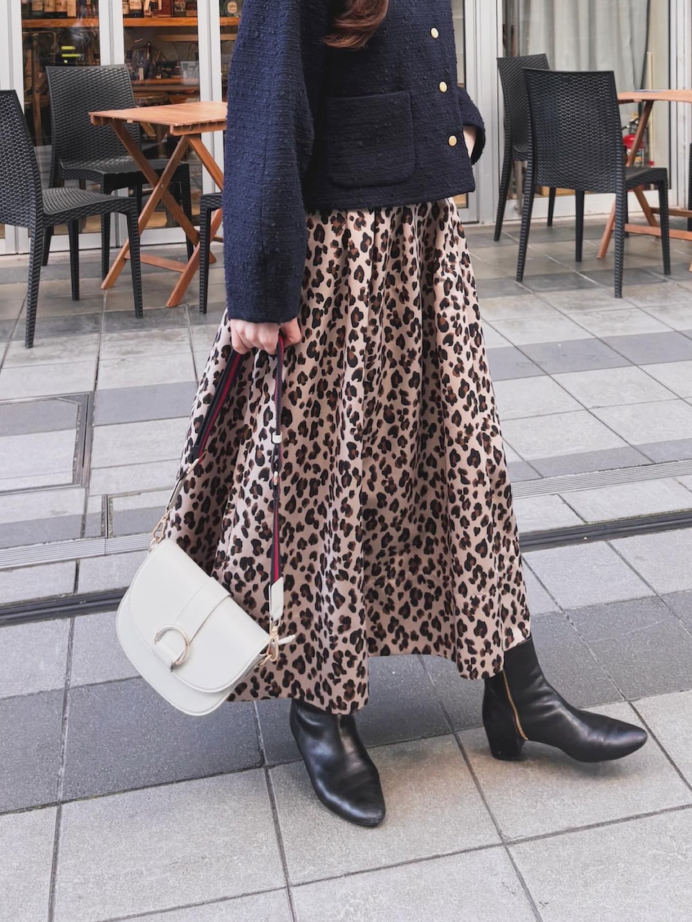 ブルー系のノーカラージャケット、ベージュ系のスカート、ホワイト系のショルダーバッグを着用したレディースの冬コーディネートの3枚目の写真