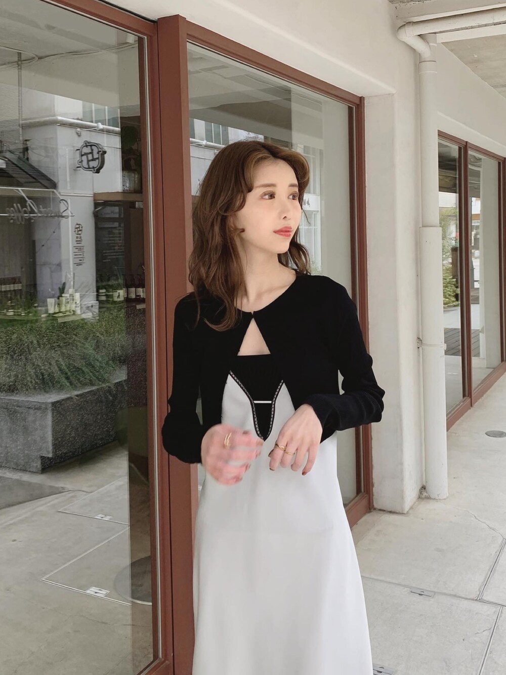 グレー系のワンピース、ブラック系のチューブトップ、ブラック系のカーディガン/ボレロを着用したレディースの春コーディネートの2枚目の写真