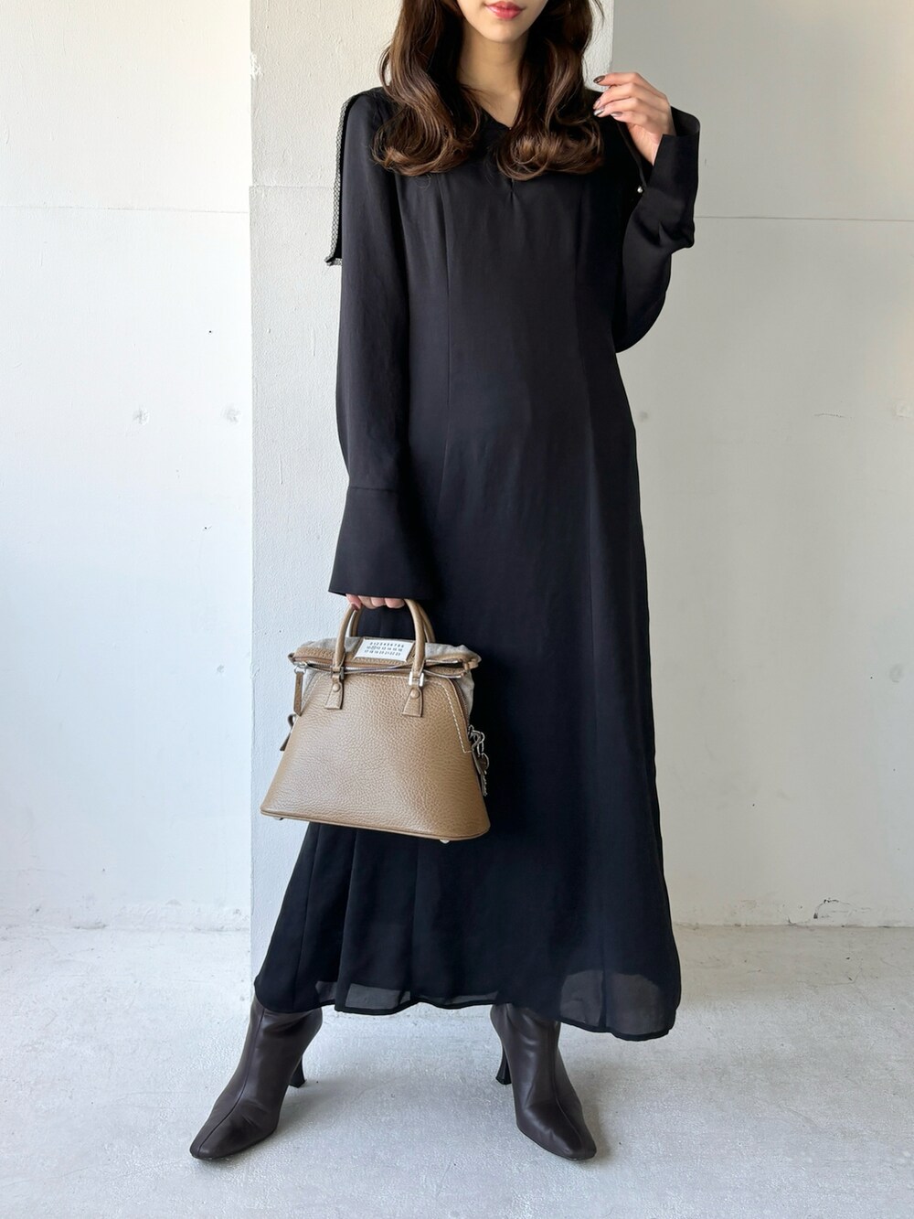 ブラック系のワンピース、ブラウン系のブーツを着用したレディースの冬コーディネートの4枚目の写真