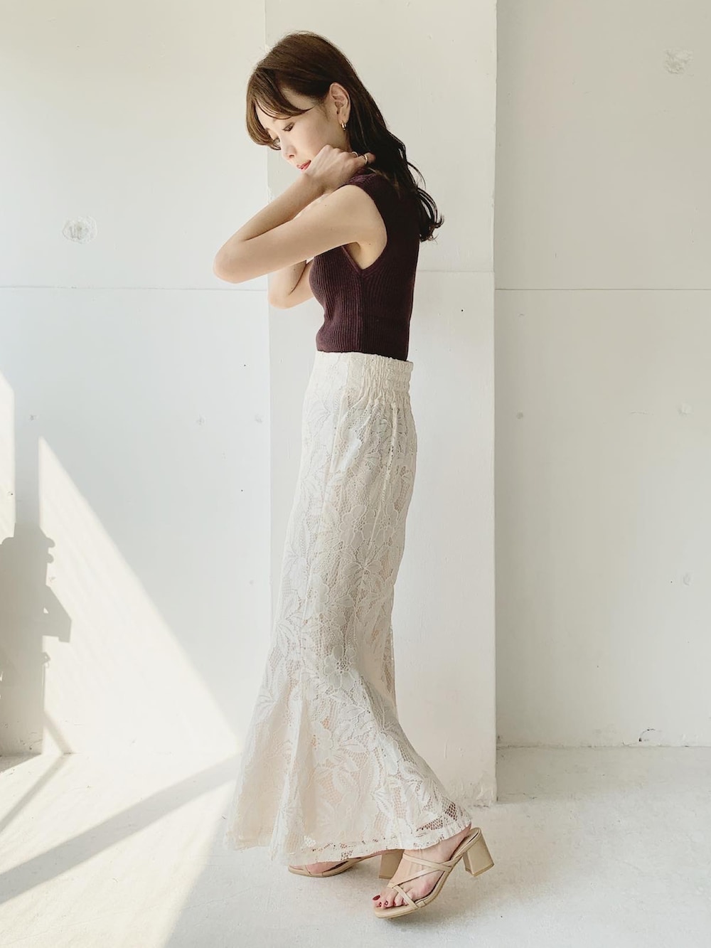 ブラウン系のニット/セーター、ホワイト系のスカート、ベージュ系のサンダルを着用したレディースの夏コーディネートの2枚目の写真