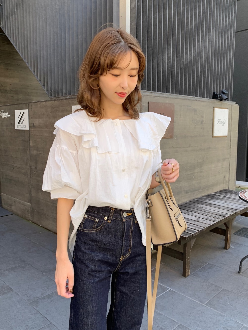 ブルー系のデニムパンツ、ホワイト系のシャツ/ブラウス、ブラック系のブーツを着用したレディースの秋コーディネートの2枚目の写真