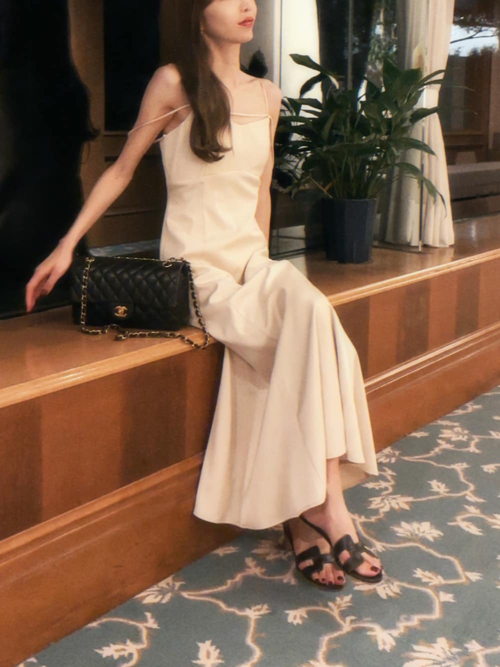 ベージュ系のワンピース、ブラック系のサンダル、ブラック系のショルダーバッグを着用したレディースの夏コーディネートの2枚目の写真