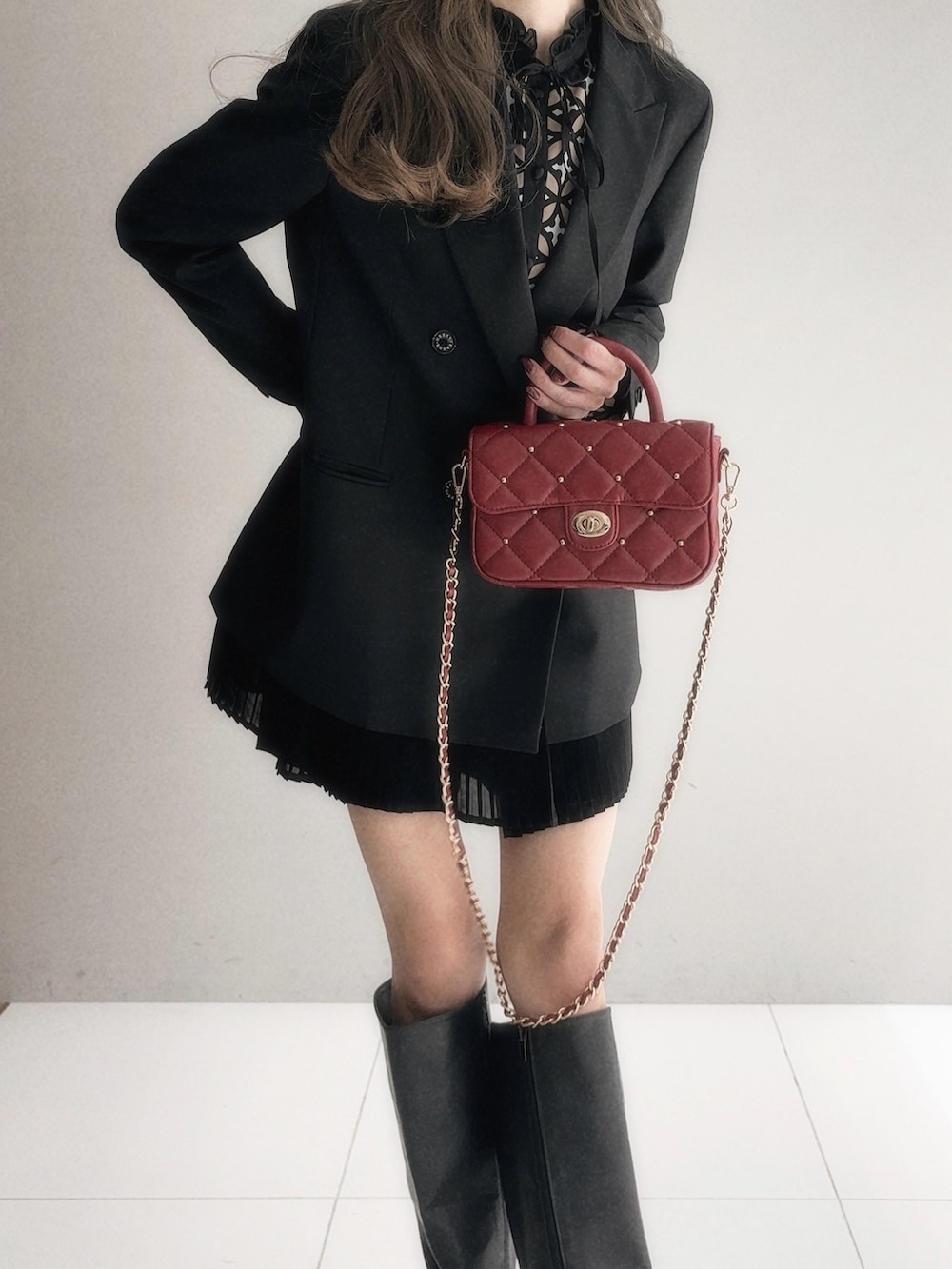 ブラック系のテーラードジャケット、ブラック系のその他パンツ、レッド系のショルダーバッグを着用したレディースの秋コーディネートの2枚目の写真