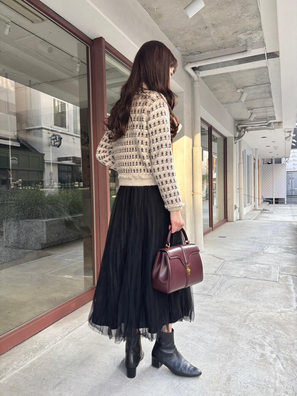 ベージュ系のカーディガン/ボレロ、ホワイト系のシャツ/ブラウス、ブラック系のスカートを着用したレディースの冬コーディネートの3枚目の写真