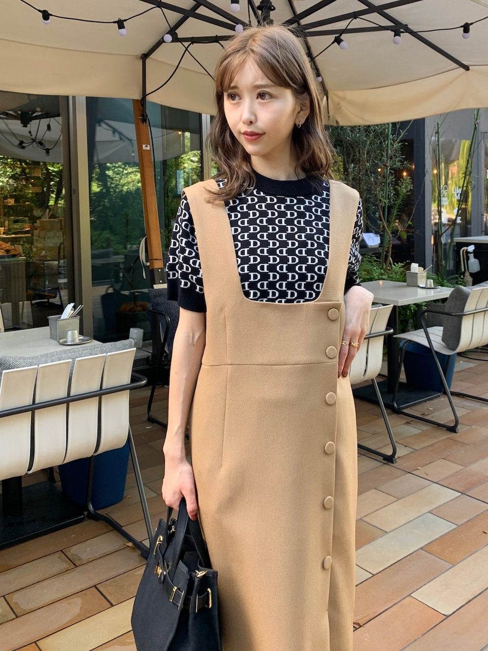 ブラック系のニット/セーター、ブラック系のショルダーバッグ、ホワイト系のブーツを着用したレディースの秋コーディネートの2枚目の写真