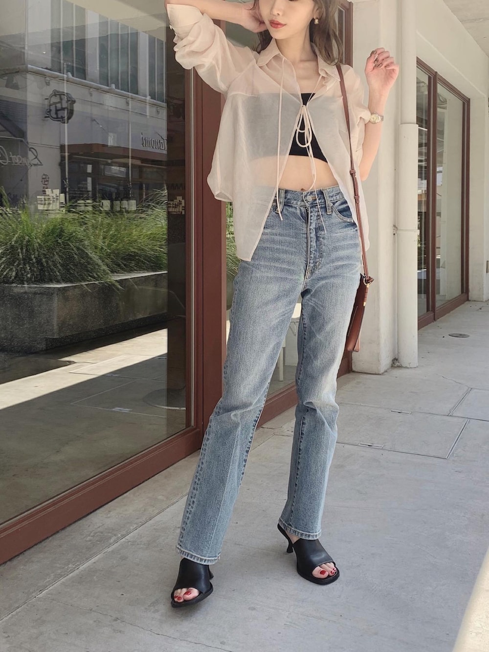 ホワイト系のシャツ/ブラウス、ブラック系のチューブトップ、ブルー系のデニムパンツを着用したレディースの春コーディネートの5枚目の写真