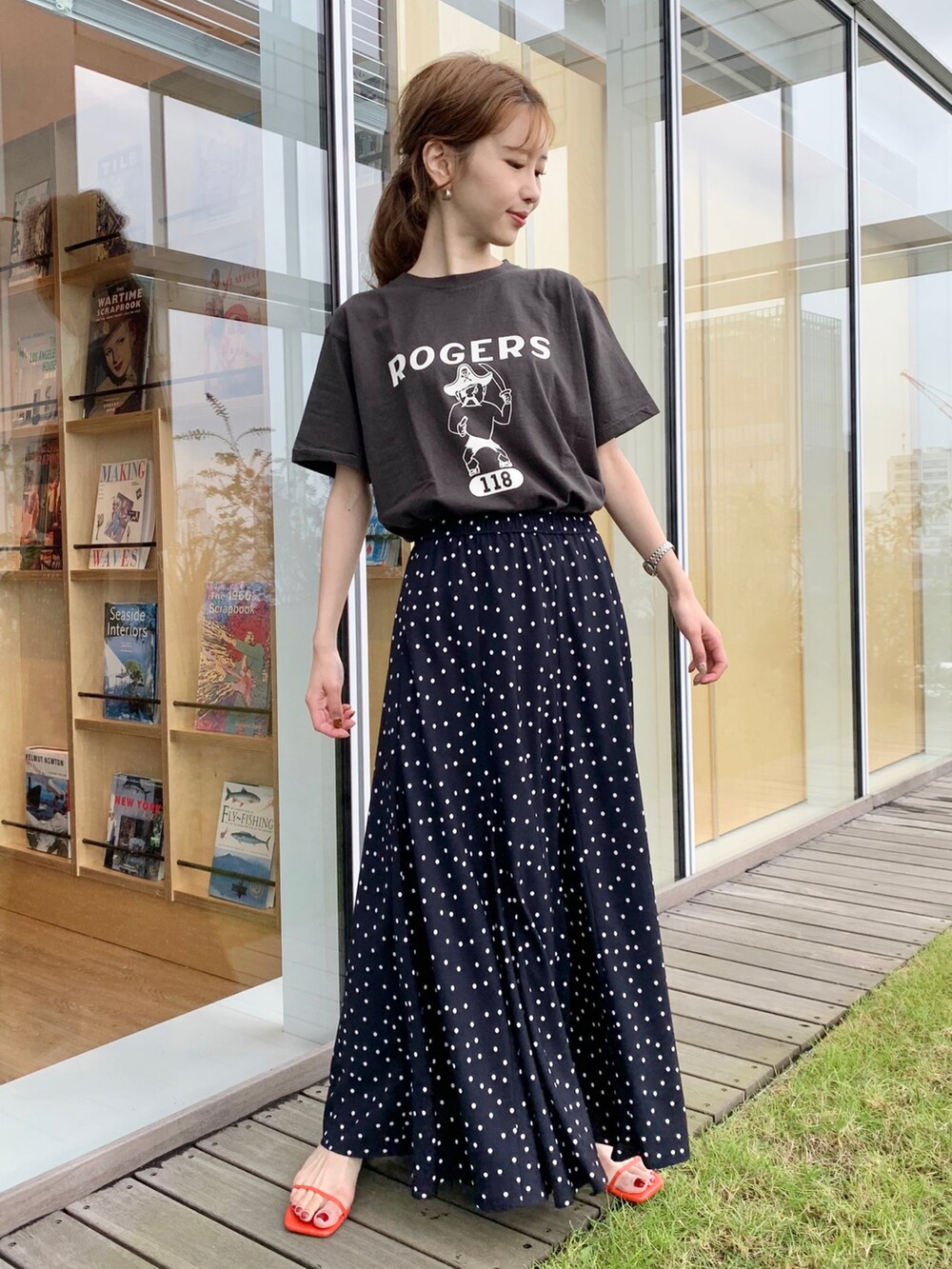 ブラック系のTシャツ/カットソー、ブルー系のスカート、ブラック系のハンドバッグを着用したレディースの夏コーディネートの2枚目の写真