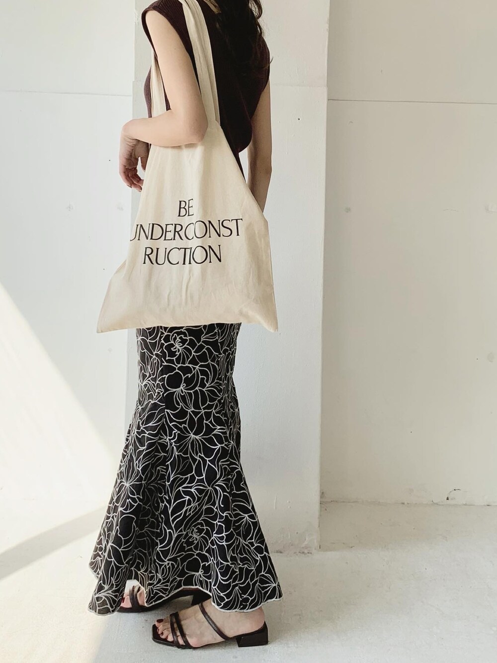 ブラック系のスカート、ブラウン系のニット/セーター、ブラウン系のサンダルを着用したレディースの夏コーディネートの2枚目の写真