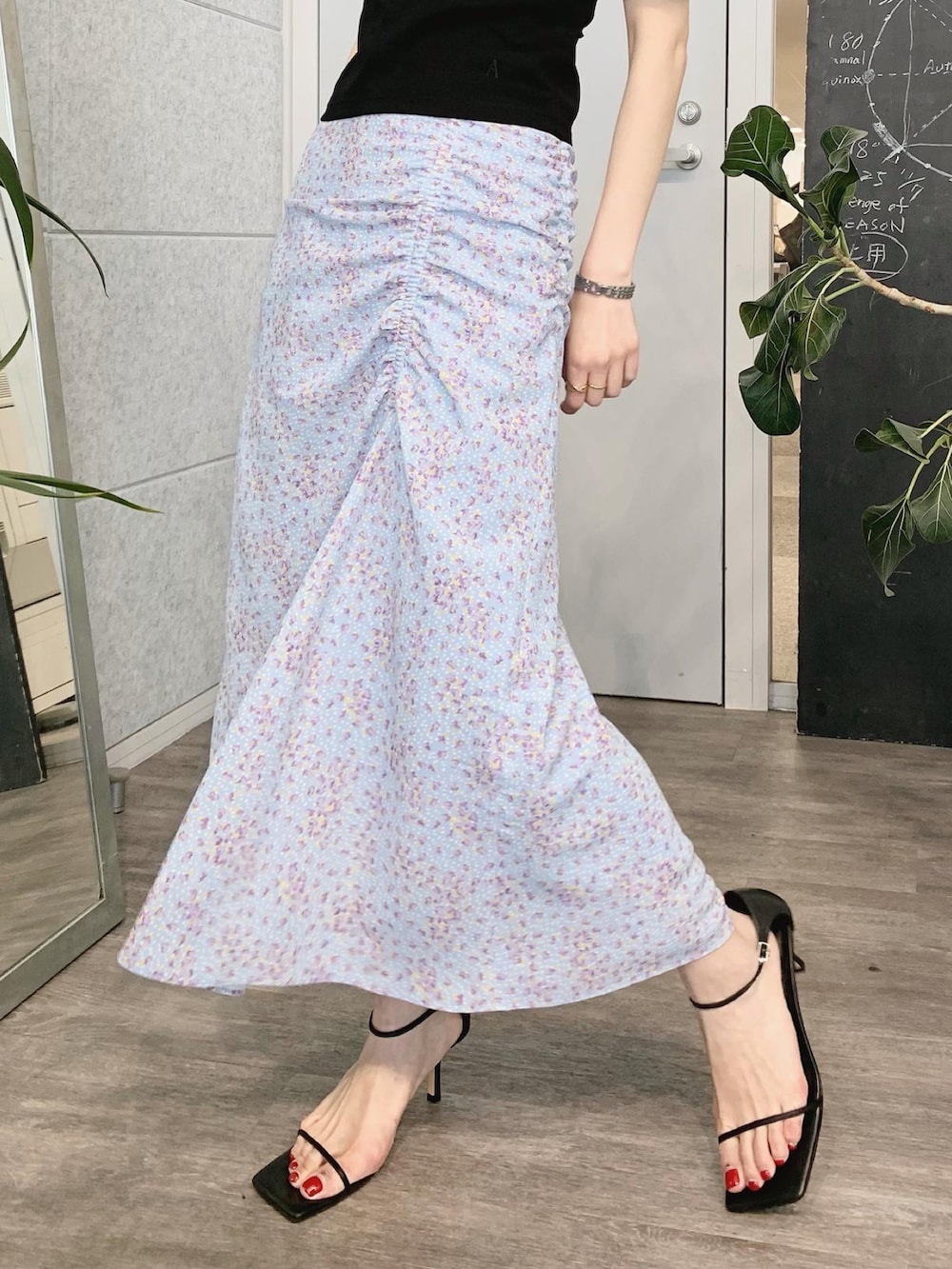 ブラック系のTシャツ/カットソー、ブルー系のスカート、ブラック系のサンダルを着用したレディースの春コーディネートの4枚目の写真