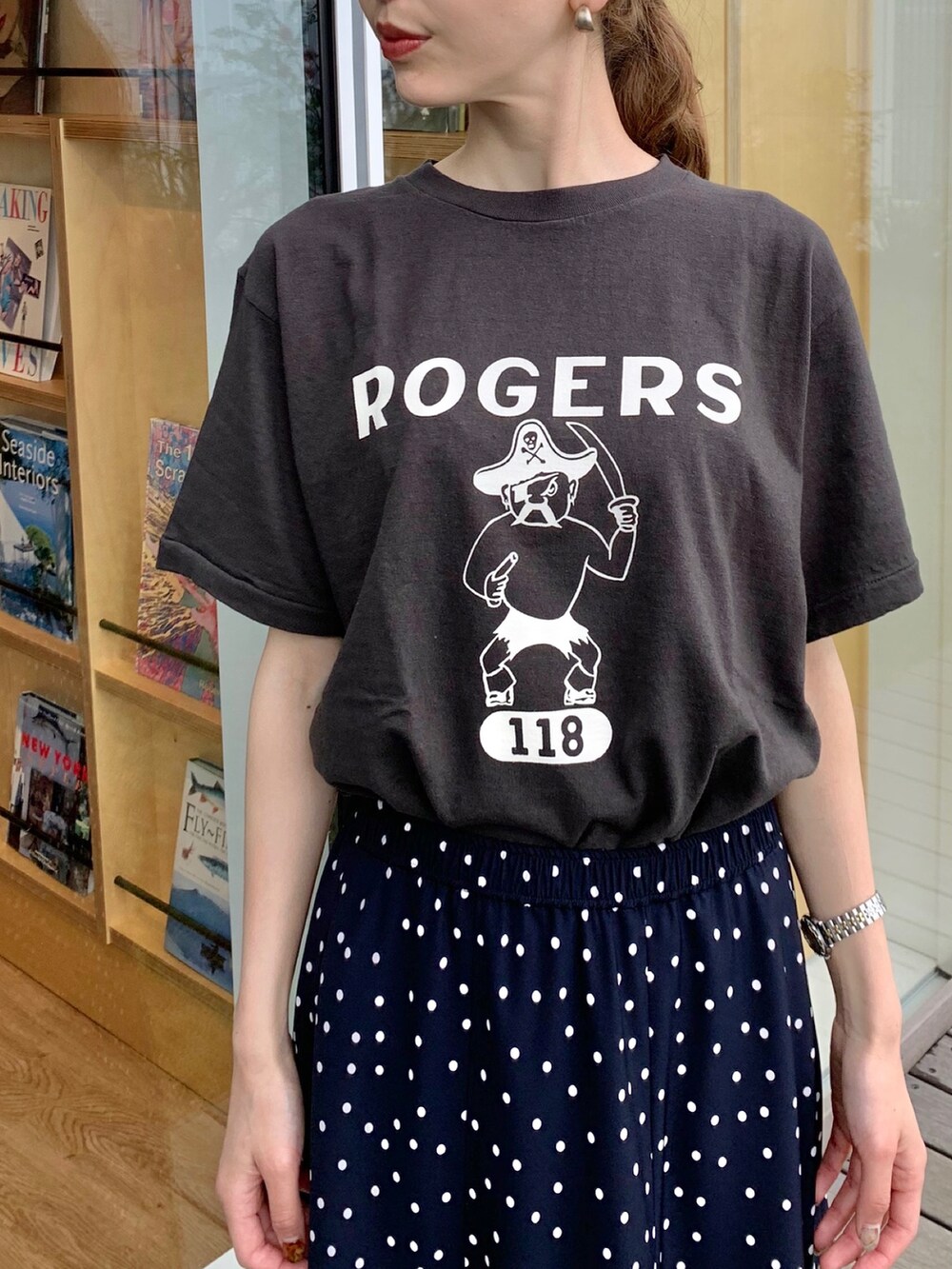 ブラック系のTシャツ/カットソー、ブルー系のスカート、ブラック系のハンドバッグを着用したレディースの夏コーディネートの3枚目の写真