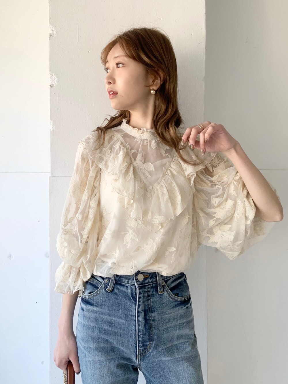 ブルー系のデニムパンツ、ブラウン系のバッグ、ホワイト系のシャツ/ブラウスを着用したレディースの春コーディネートの3枚目の写真