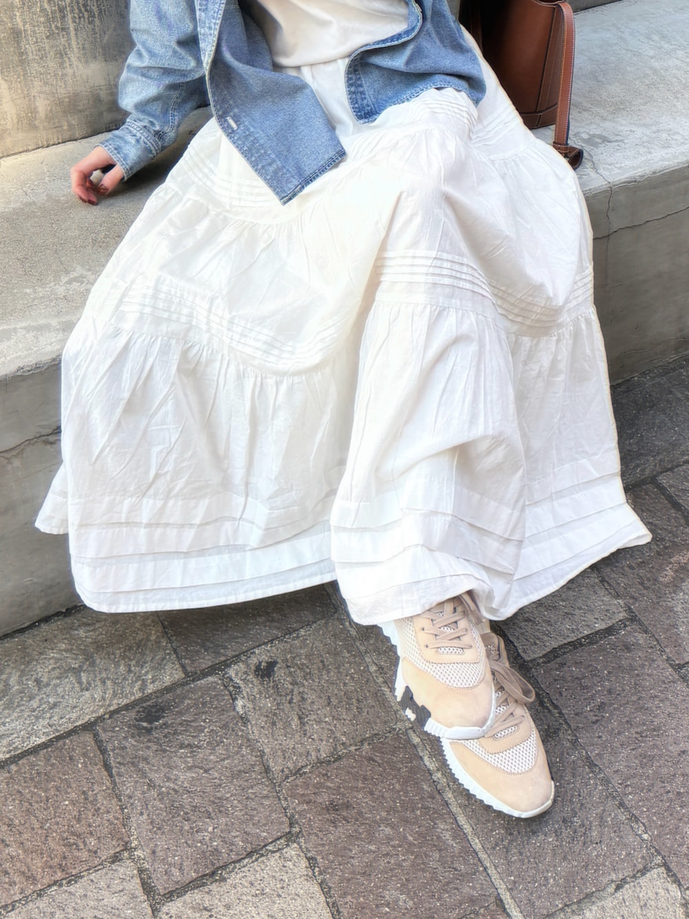 ブルー系のシャツ/ブラウス、ホワイト系のスカート、ベージュ系のTシャツ/カットソーを着用したレディースの春コーディネートの3枚目の写真