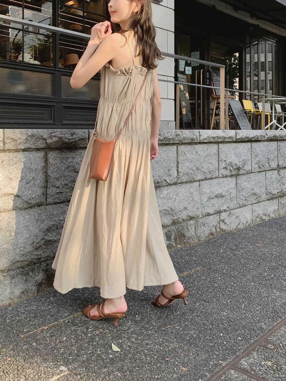 ベージュ系のワンピース、ブラウン系のショルダーバッグ、ブラウン系のサンダルを着用したレディースの夏コーディネートの2枚目の写真