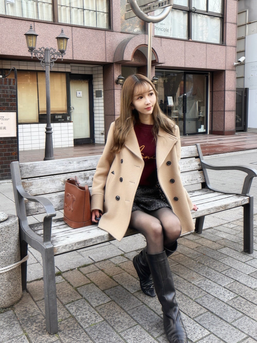 ベージュ系のピーコート、ブラック系のその他パンツ、ブラウン系のニット/セーターを着用したレディースの冬コーディネートの2枚目の写真